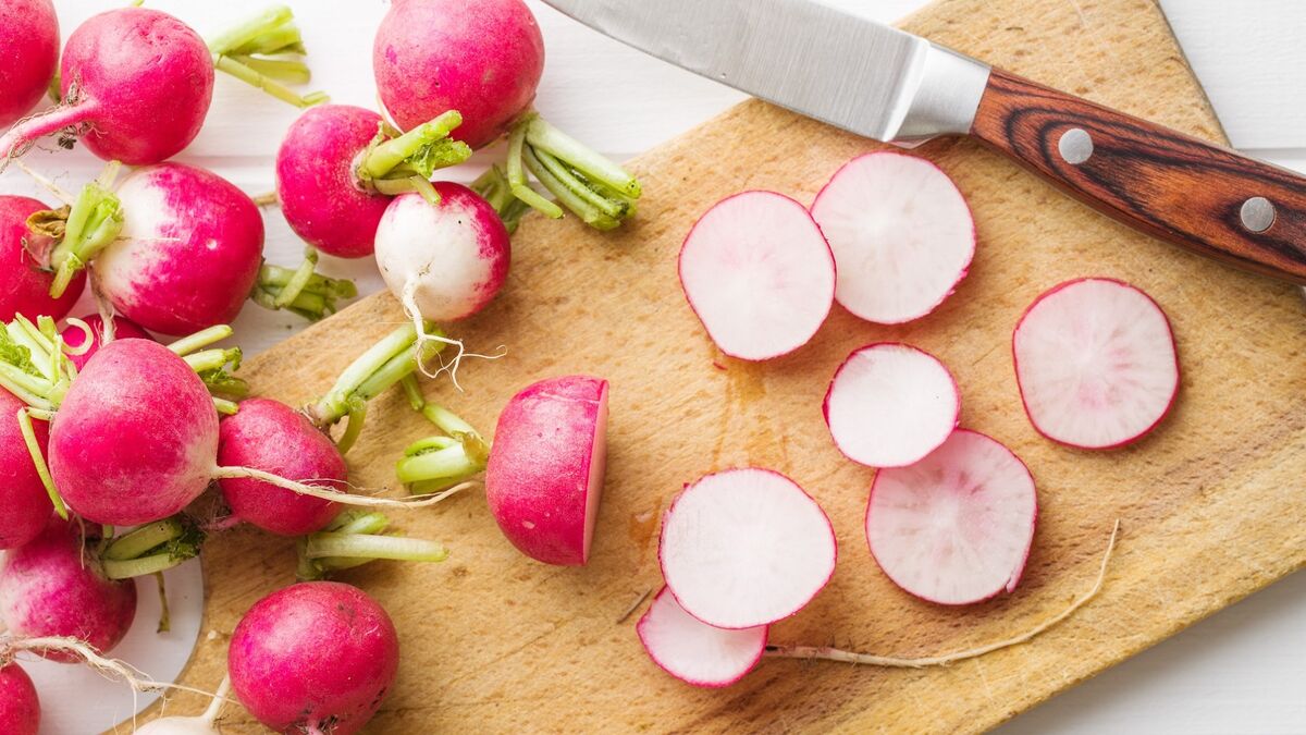 Вкусный редис. Букет из редиски и зелени. Редис нарезанные на белом фоне вид сверху. Весенней фон для меню с редиской. Редис 2 месячный