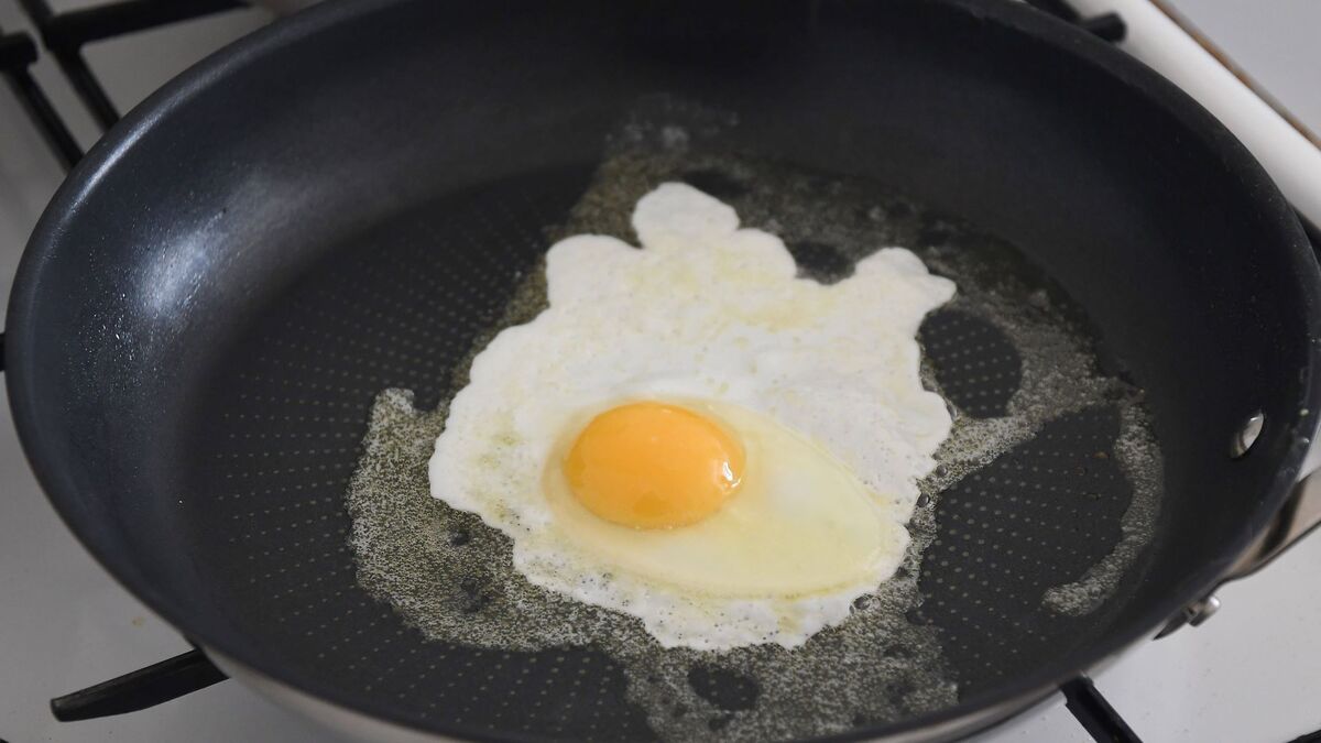 яичница прилипает. яичница прилипает. как готовить яичницу. глазунья из одного яйца на сковородке. сковородка с яичницей в руках.