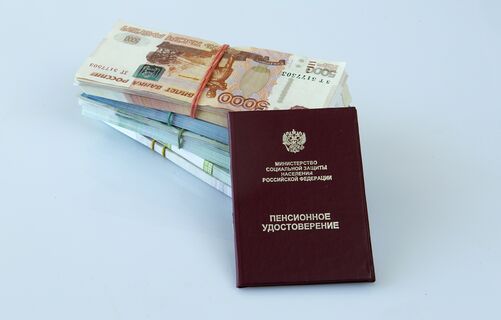 Пенсионное удостоверение на двух пачках бумажных купюр