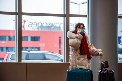 Китаянка в медицинской маске в аэропорту