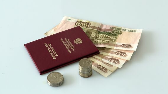 Пенсионное удостоверение и деньги на столе