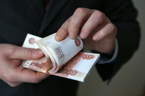 Пачка пятитысячных купюр в руке