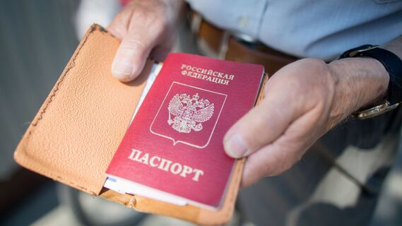 Мужчина держит российский паспорт